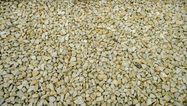 A large collection of gold quartz stones labeled 'GOLD QUARTZ 20MM' spread evenly on the ground.