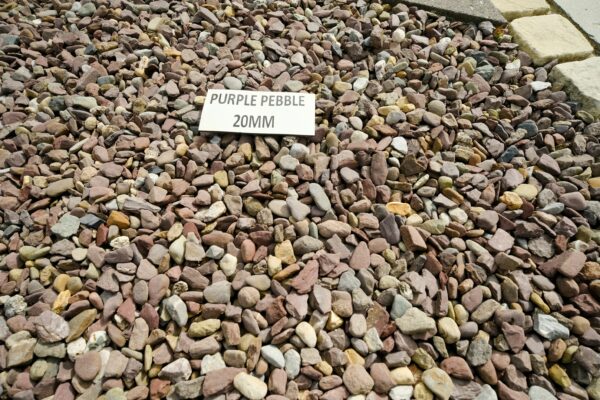 A collection of multicolored pebbles with a sign that reads "PURPLE PEBBLE 20MM" placed on top.